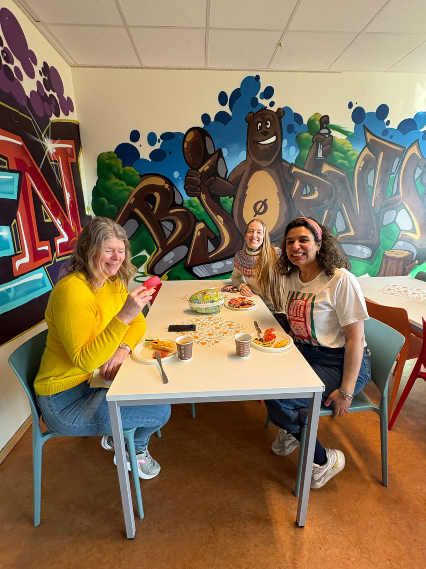 En gruppe personr sitter ved et bord og spiser mat