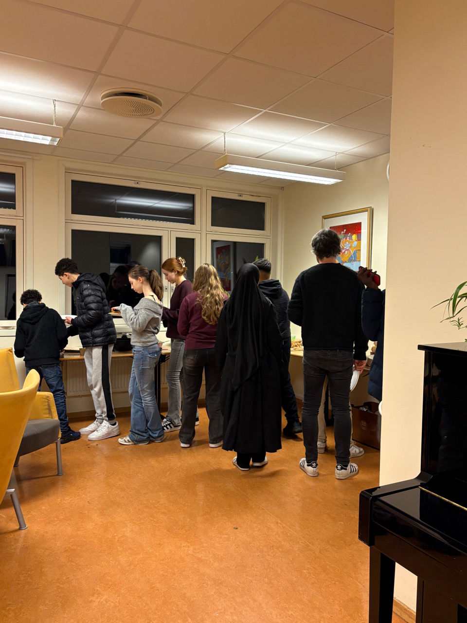 en gruppe mennesker som står i et rom