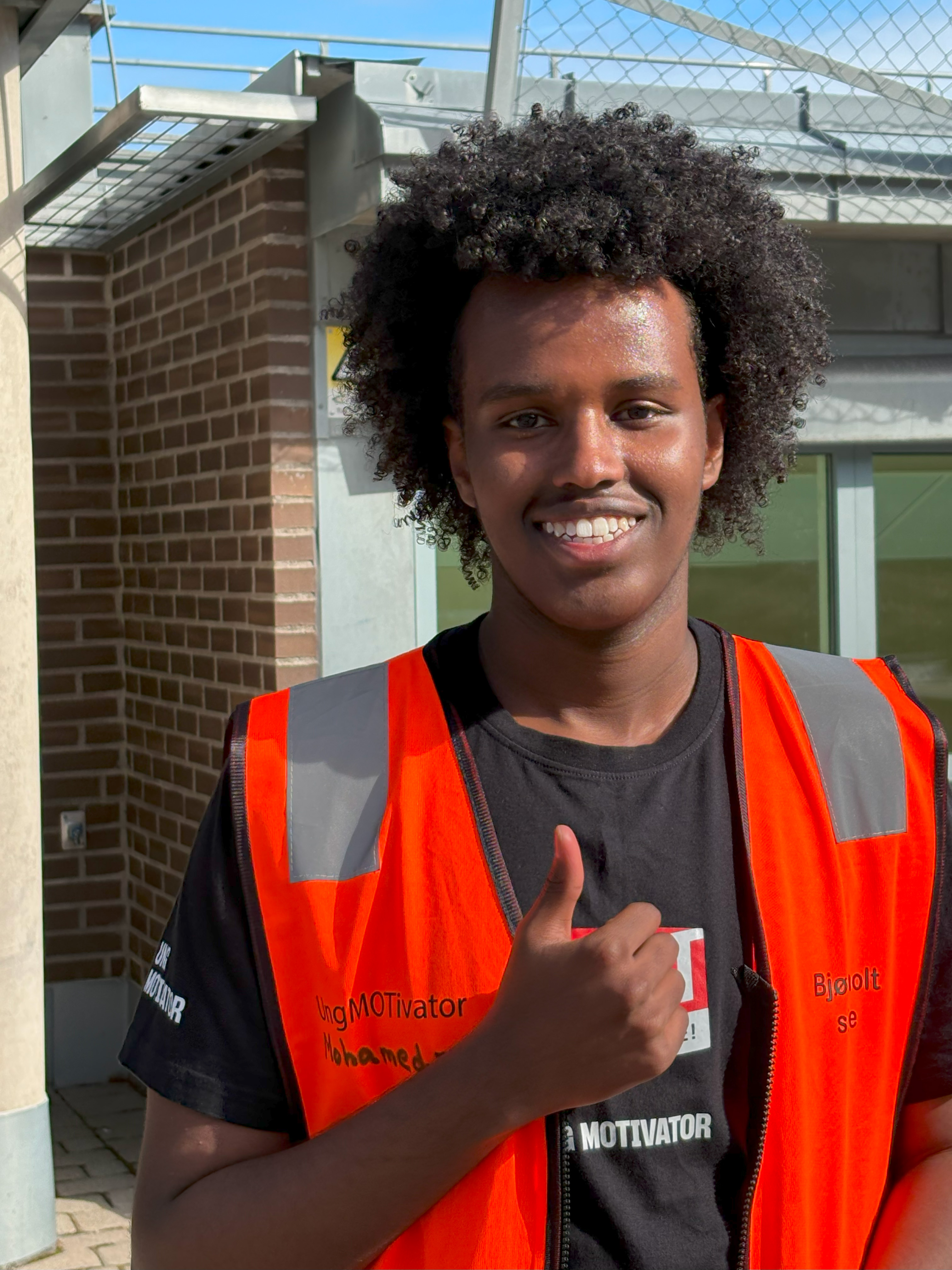 en person som smiler med krøllete hår