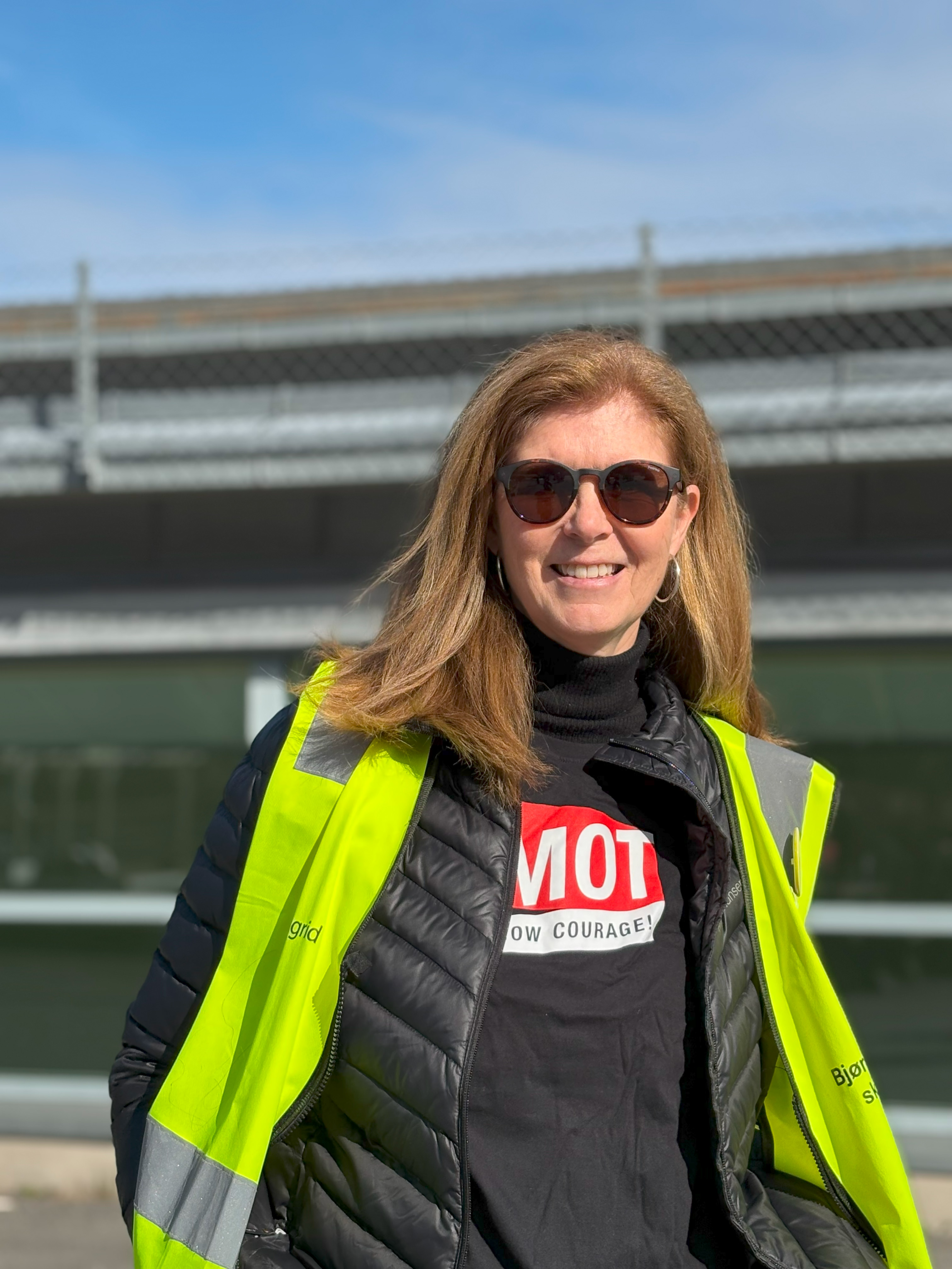 en person som bruker solbriller og en grønn jakke